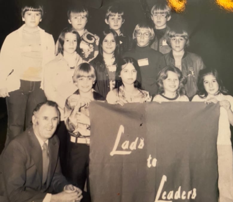 Dr. Jack Zorn, left, sits with a group of young students at a Lads2Leaders Convention. 