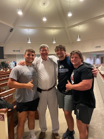 Students posed with President Mitch Henry, center after being baptized. 