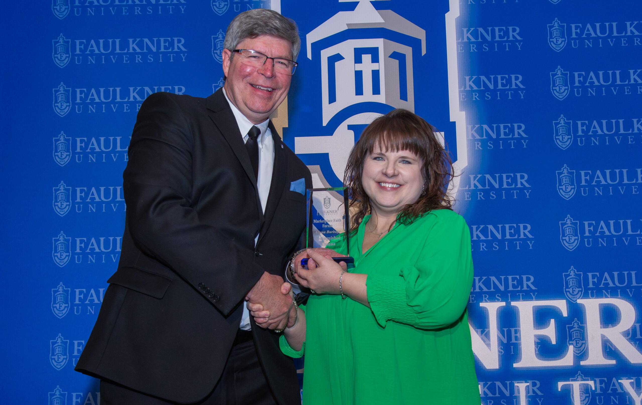 Allena Burbage receives the Distinguished Alumna Award from President Mitch Henry. 