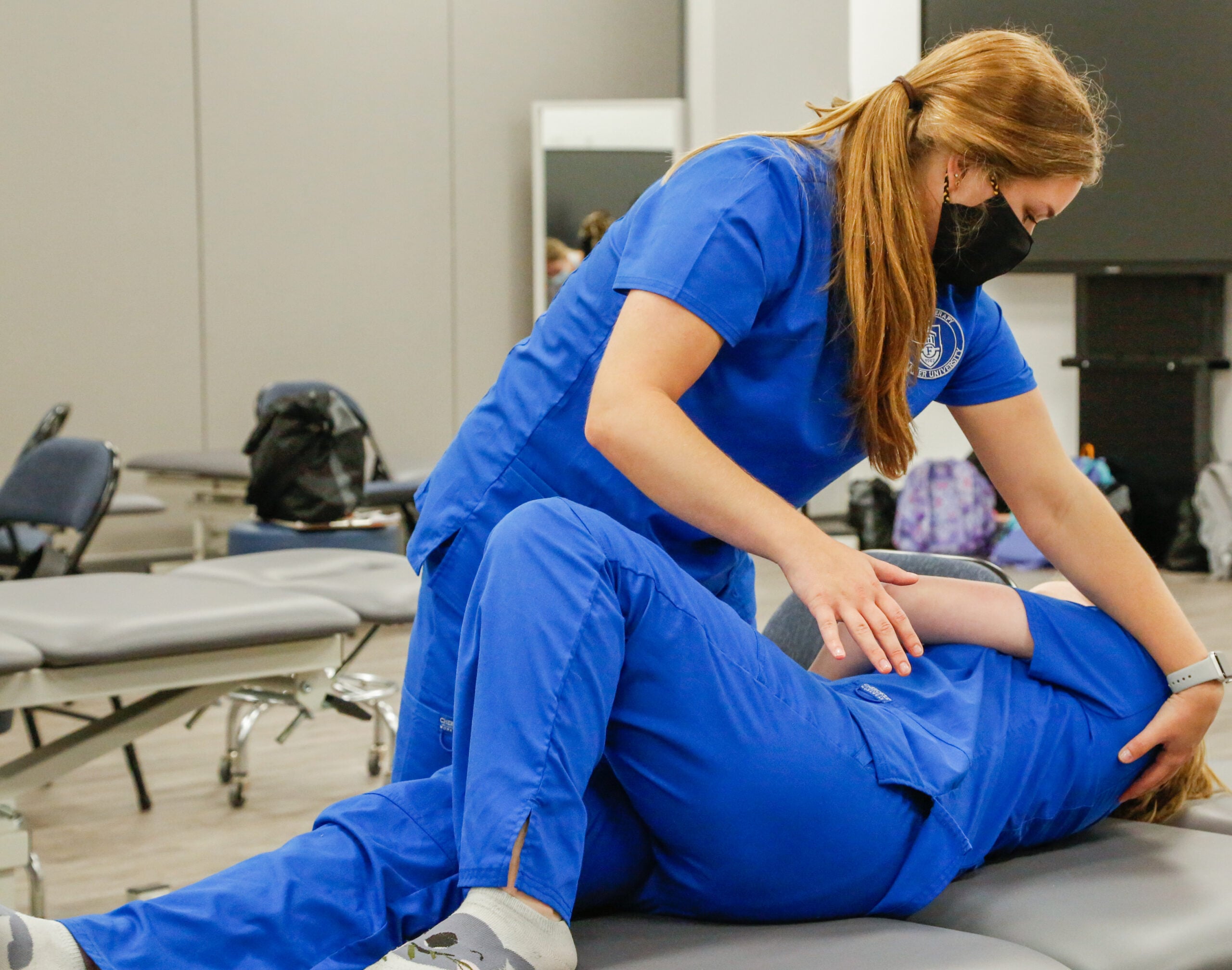 Physical Therapy students practice during a lab session. They have earned accreditation.