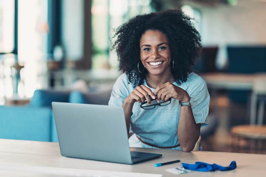 Student Smiles While Working at Laptop Computer