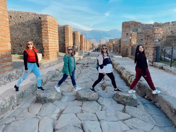 Study Abroad students crossing rocks.