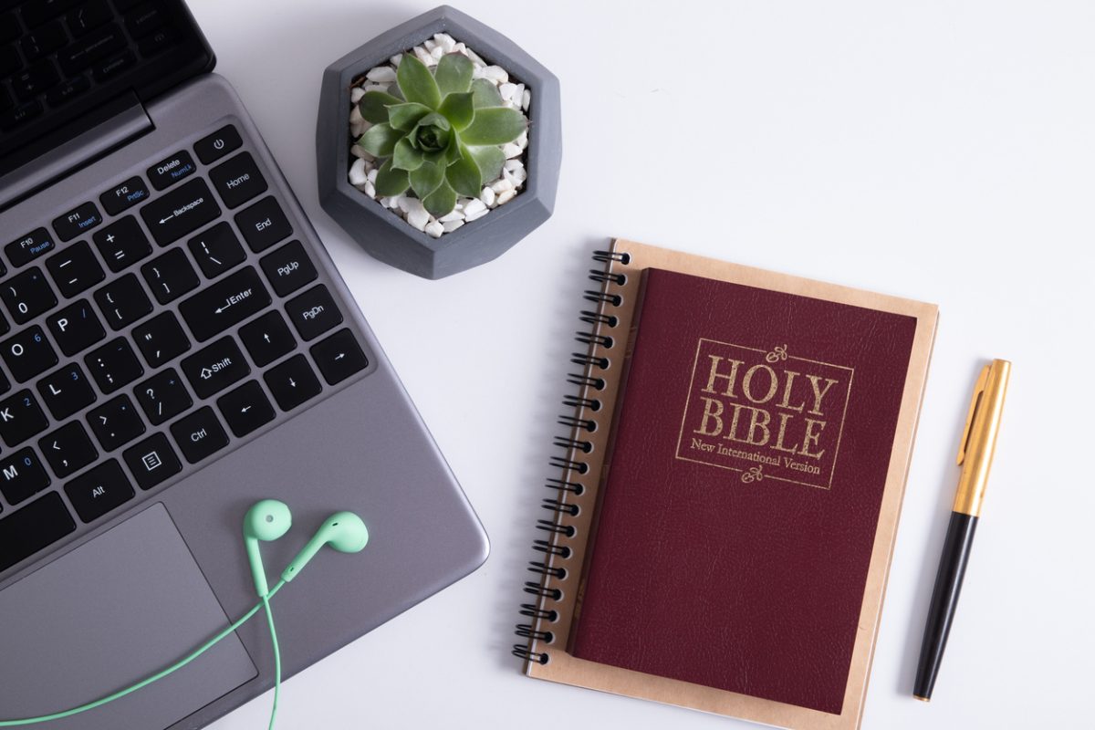 Bible, laptop, and headphones on worktable