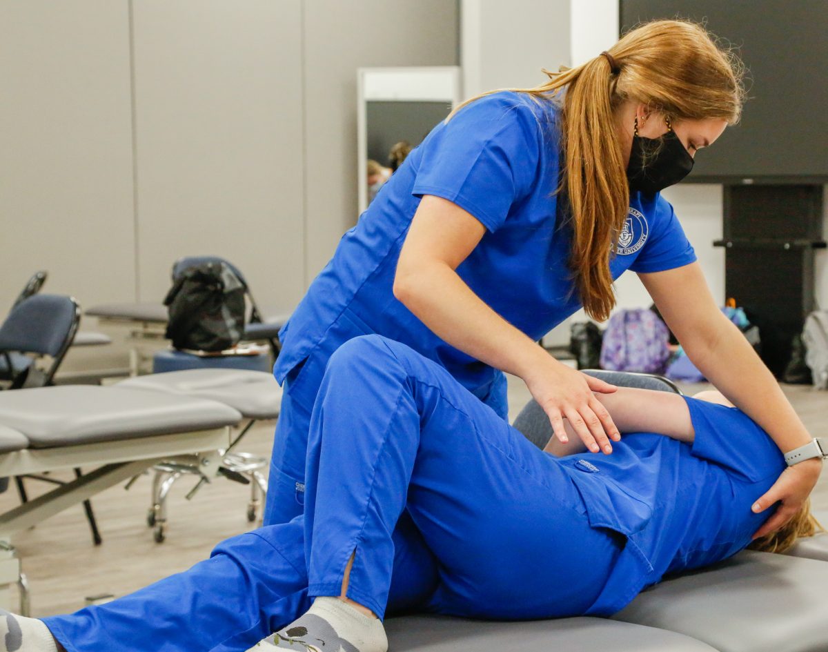 Physical Therapy students practice during a lab session. They have earned accreditation. 
