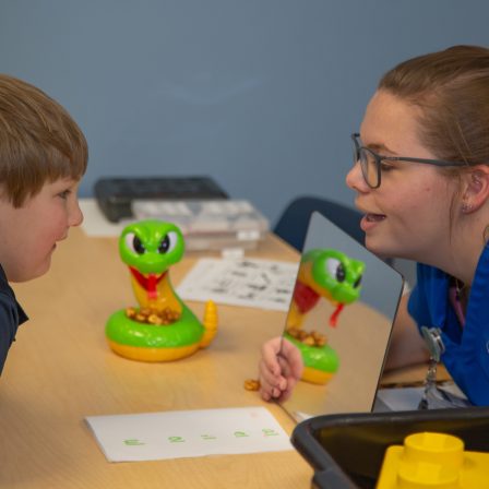 A young patient works on his speech therapy inside the clinic.