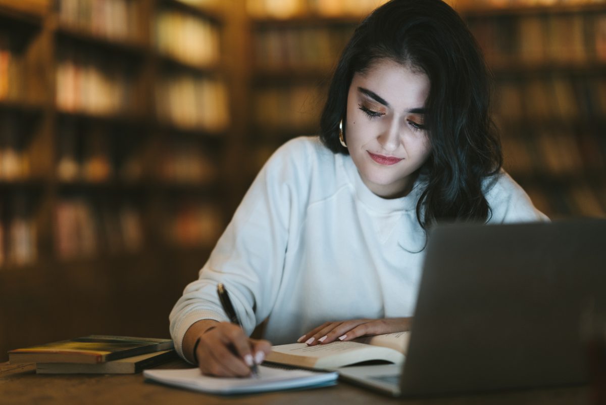 College student studying online at library 