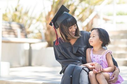 Female Graduate Sitting with a Young Girl