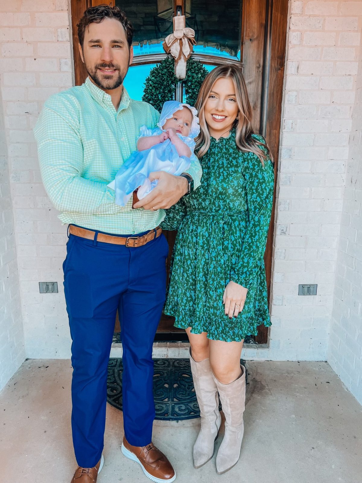 l-r, Hunter Wilson, wife McKenzie and faughter Maren pose for a family photo in front of a door.