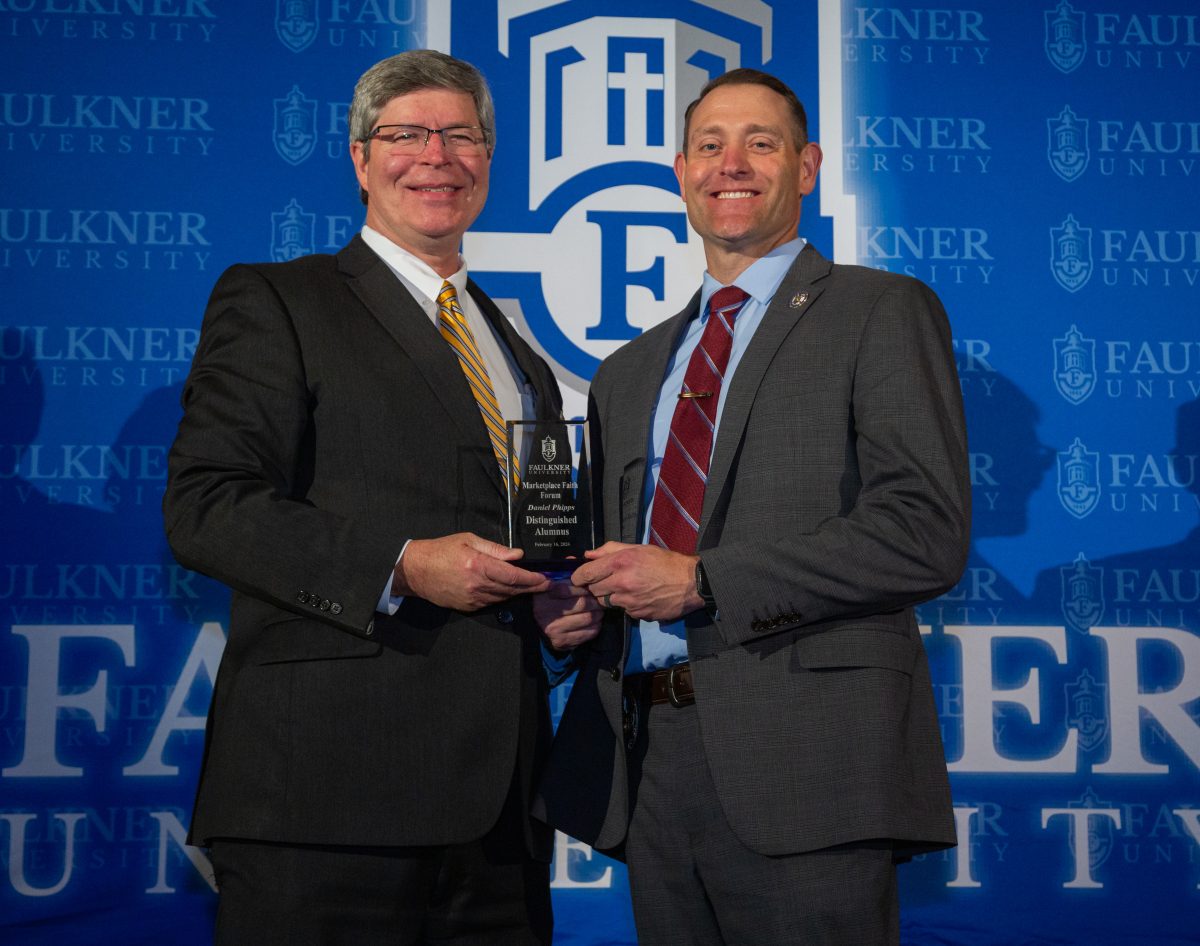 President Mitch Henry awards Captain Daniel Phipps at the 2024 Marketplace Faith Friday Forums. 