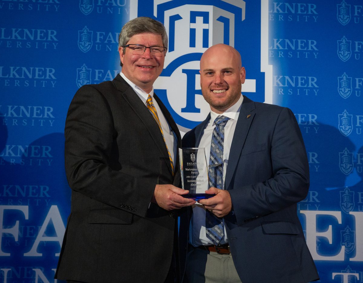 President Mitch Henry, left, presents John Dockins with the Distinguished Alumnus of the Year Award.