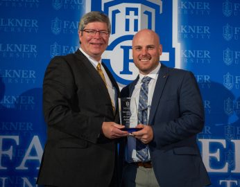 President Mitch Henry, left, presents John Dockins with the Distinguished Alumnus of the Year Award.