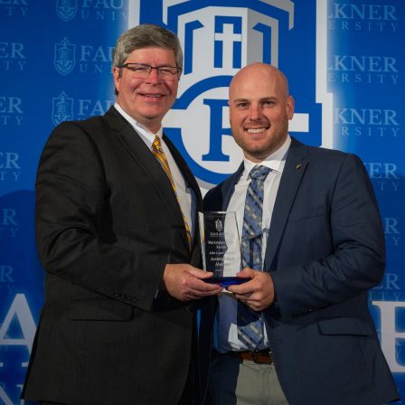 President Mitch Henry, left, presents John Dockins with the Distinguished Alumnus of the Year Award.