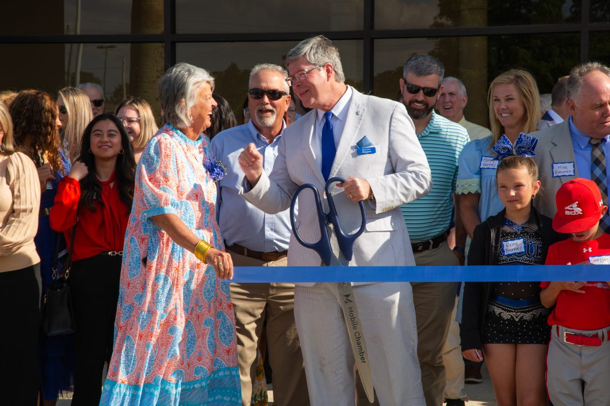 Lisha May and President Mitch Henry share a laugh before the ribbon cutting of the Mobile campus. 