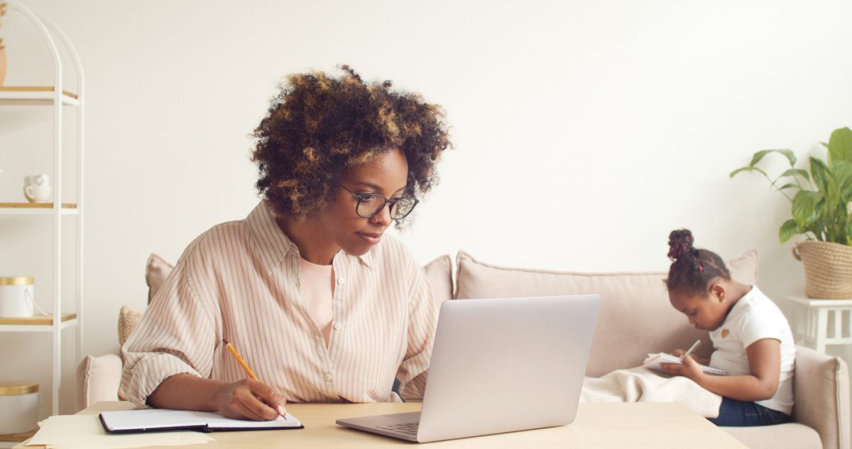 Parent studying online with child in background