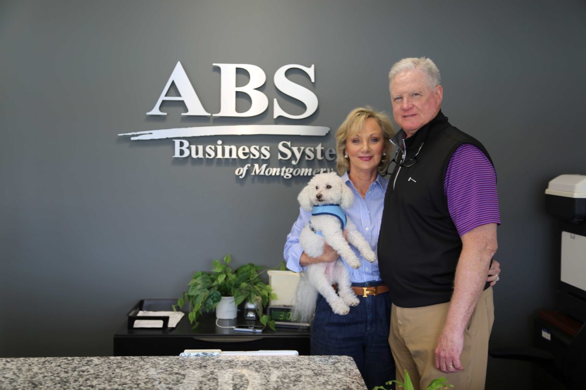 l-r Judy and Eddie Cobb stand in front of the ABS logo. They are supporters of the Zorn Scholarship Fund. 